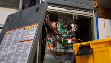 Inside of a furnace with wires exposed.