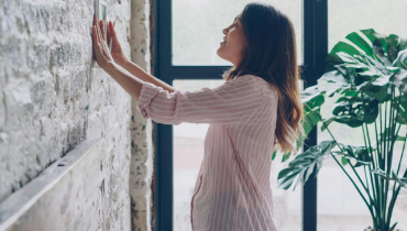 House Owner Is Decorating Her Loft Style Room Hanging Picture on Brick Wall.