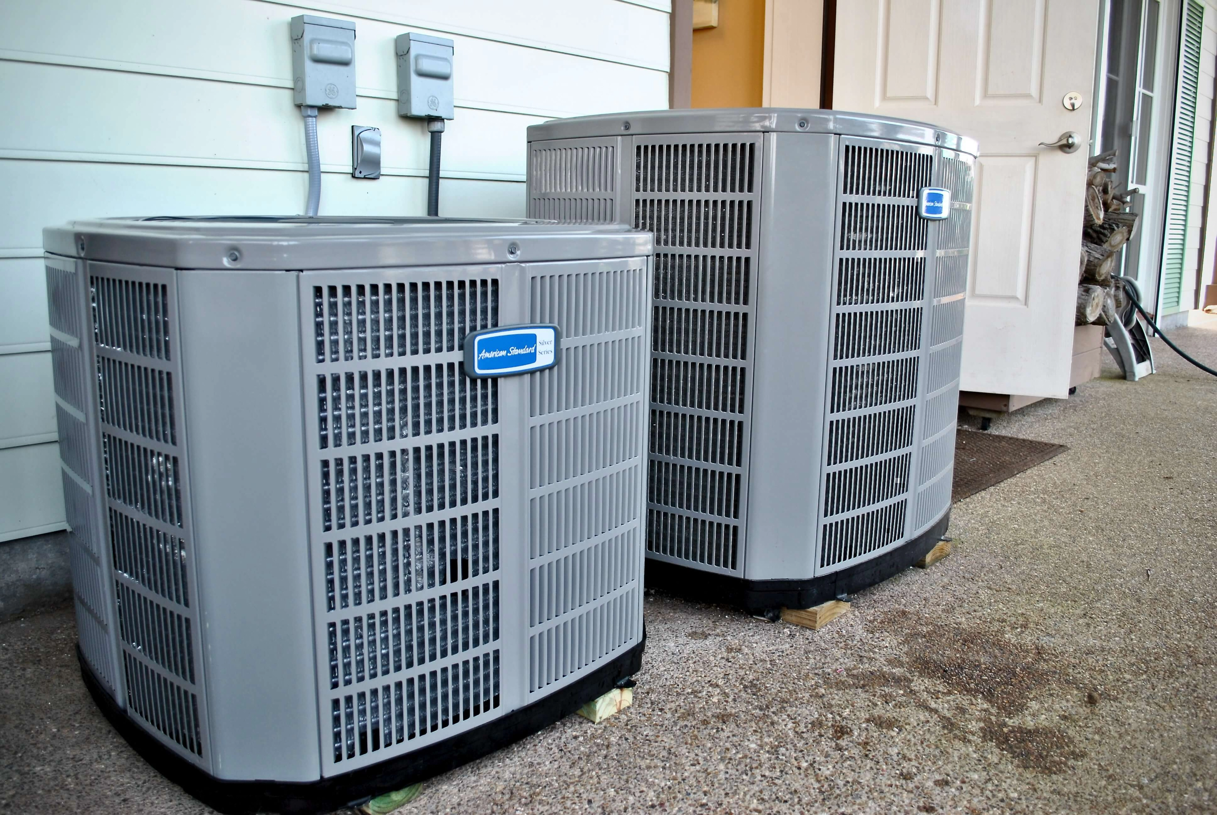 A set of air conditioner units outside of a home