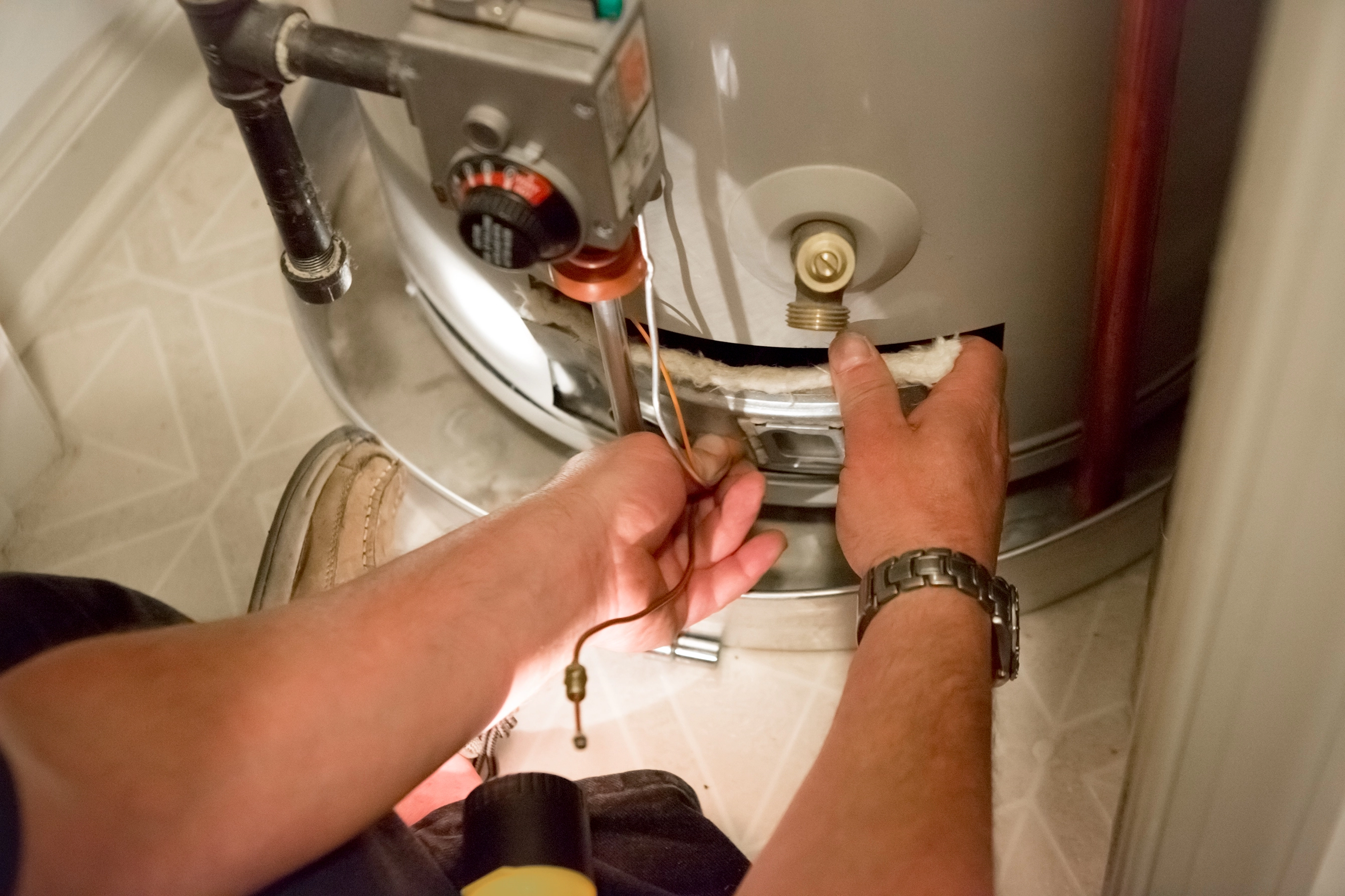 Close-up technician's  hands adjusting boiler unit.