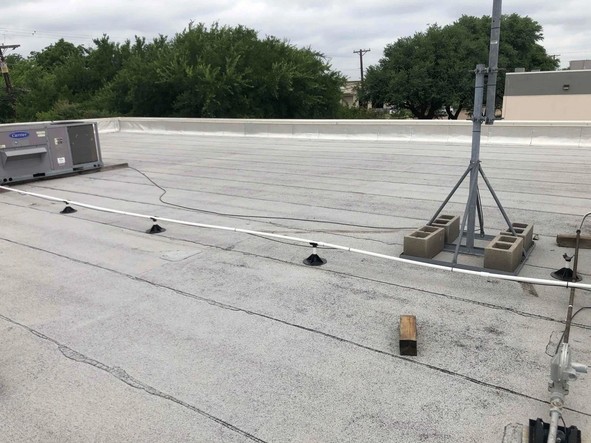 Servicing rooftop heating unit on commercial building in Dallas.
