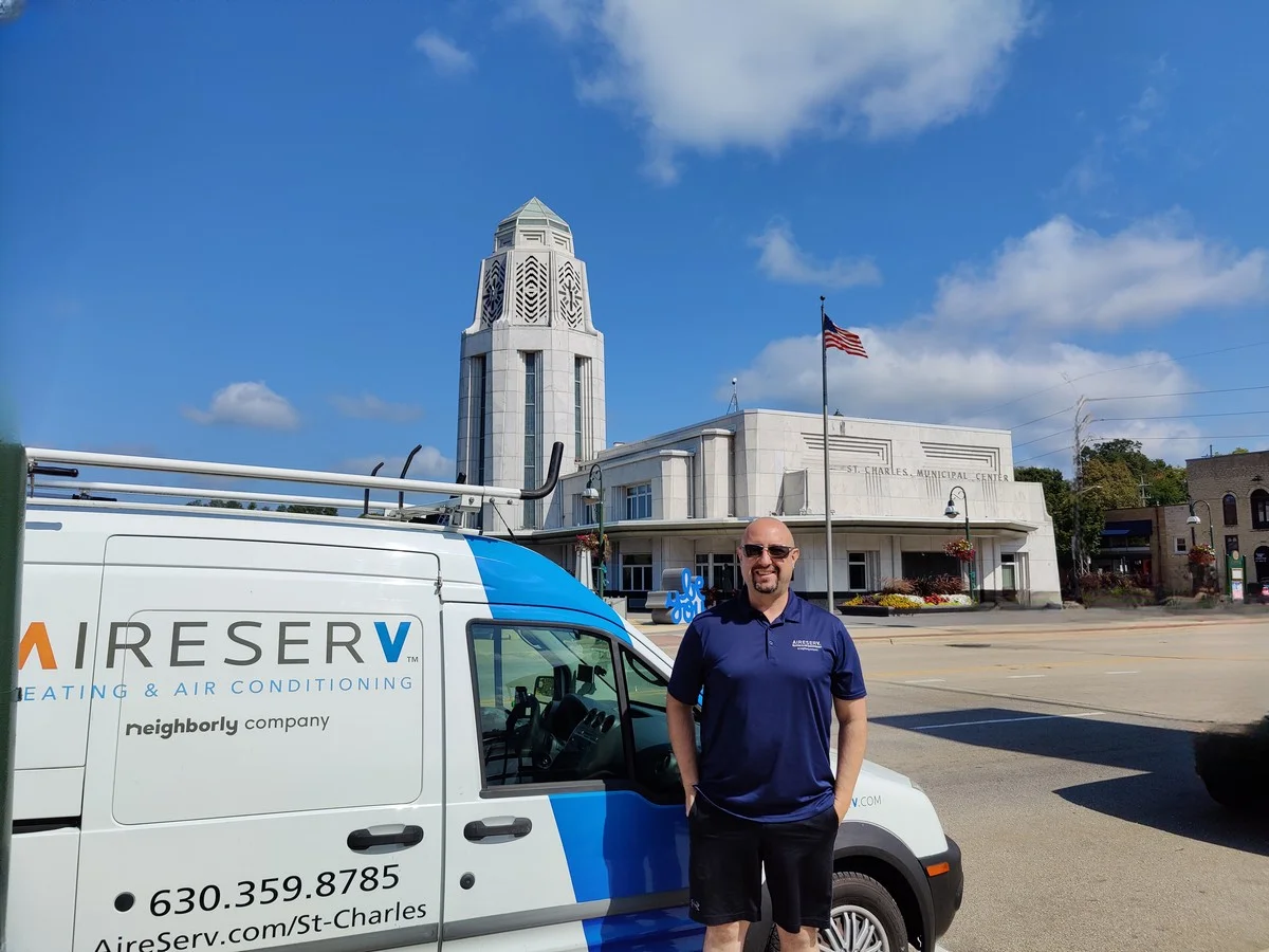 Aire Serv of St. Charles service tech standing in front of branded company van.