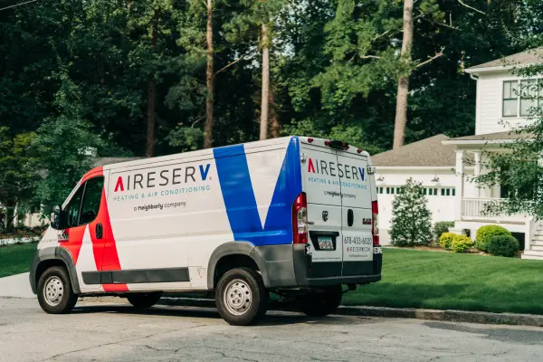 Aire Serv branded van parked on residential suburban street.
