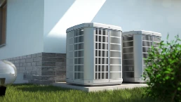 A set of 2 central AC units outside of a home