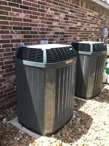 Two outdoor HVAC units outside a home that has recently received service for new HVAC installation in Garland, TX.