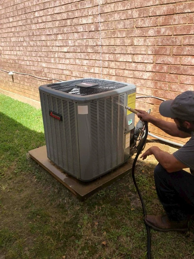  An outdoor HVAC unit in Irving, TX as it is being serviced and cleaned by an HVAC professional from Aire Serv.