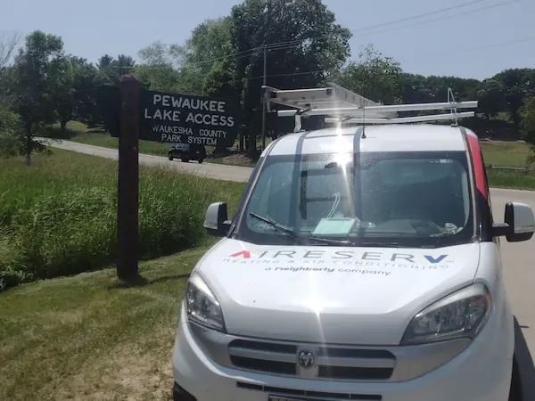 Aire Serv branded van beside Pewaukee Lake Access sign.